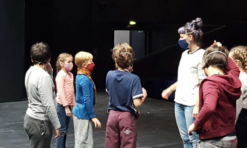 Kinder mit einer Theaterpädagogin auf der Bühne im ATZE.